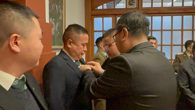 Un alguacil pone la piocha en la solapa de un nuevo integrante