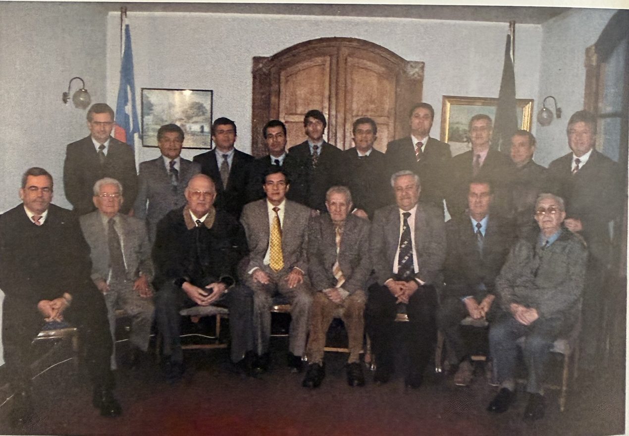 Foto grupal de los alguaciles del círculo en 2004, frente a una puerta de madera en arco